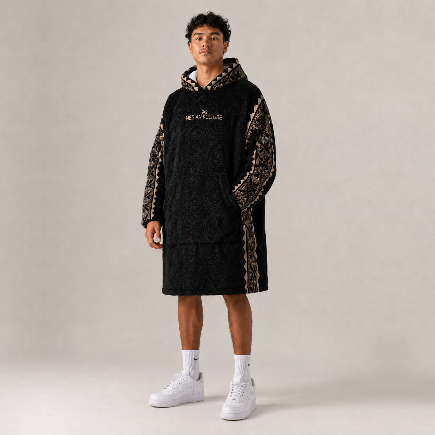 Nesian Kulture black and gold oversized snug hoodie, angled front view with sleeve detailing