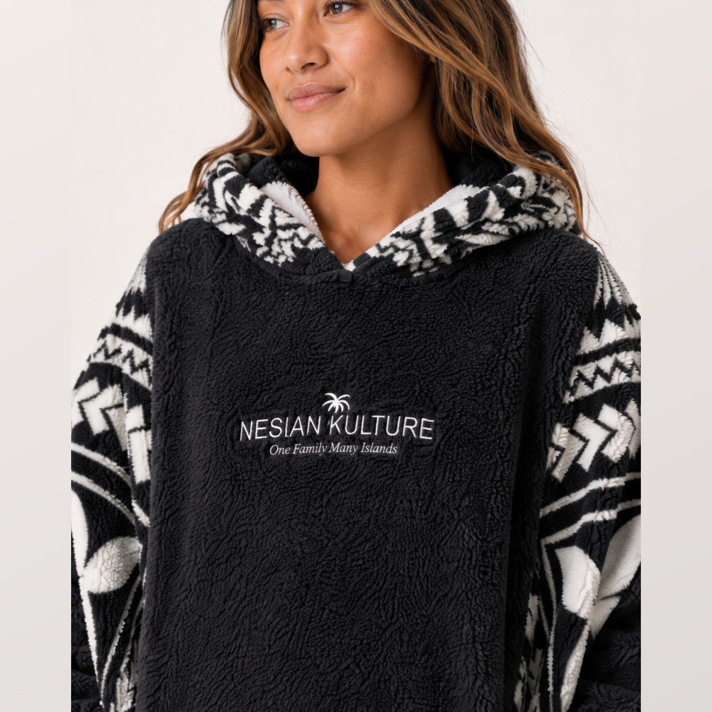 Nesian Kulture charcoal fleece snug hoodie close-up showing chest logo, hood lining and soft fabric texture