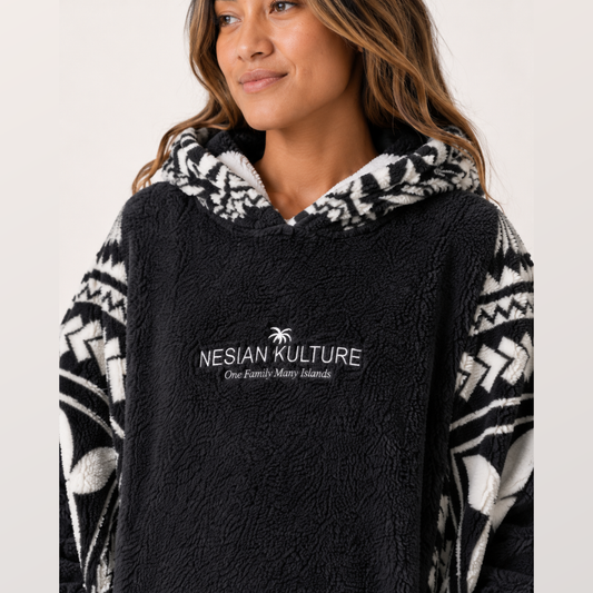 Nesian Kulture charcoal fleece snug hoodie close-up showing chest logo, hood lining and soft fabric texture