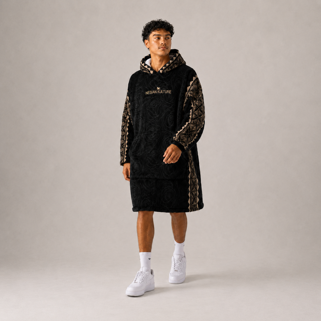 Nesian Kulture black and gold oversized snug hoodie, walking pose in studio