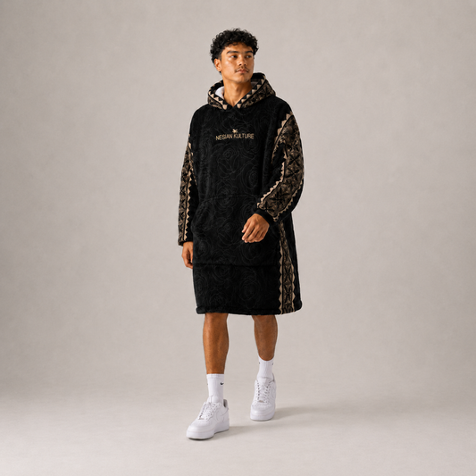 Nesian Kulture black and gold oversized snug hoodie, walking pose in studio