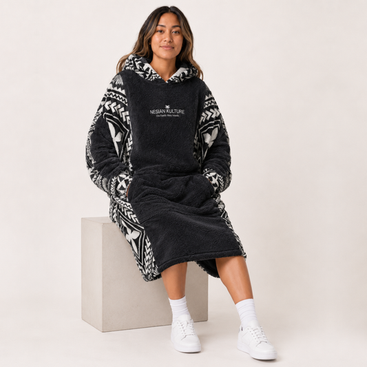 Nesian Kulture charcoal and white oversized snug hoodie, seated lifestyle view with soft fleece texture